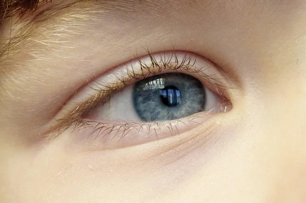 Right eye of a white child close-up, soft focus. The human eye with a blue pupil — Stock Photo, Image