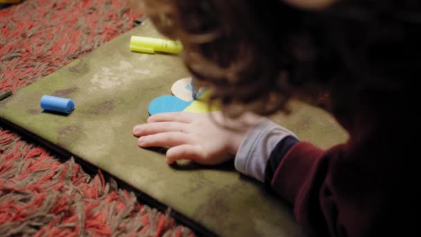 Un enfant peint un cœur aux couleurs du drapeau de l'Ukraine, vue de côté — Video