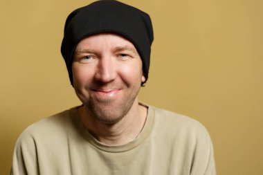 Siyah şapkalı adam seviniyor. Surat yapan genç bir adamın portresi