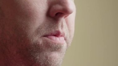 Beyaz adam cips yiyor. Adam ağzına cips koyar ve uzun süre çiğner. Yakın plan, kenar görünüm