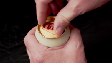 Odessa, Ukrayna - 3 Haziran 2022: İnsan eli soğuk bir Krombacher cehennem birasını açar, siyah arka plan