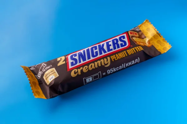 Csokoládé Szelet Snickers Kék Háttérrel Lágy Fókusz — Stock Fotó