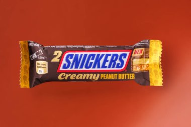 Turuncu arka planda Snickers çikolatası, üst manzara.