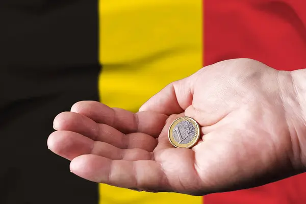 一个人手里拿着一欧元 背后挂着比利时国旗 — 图库照片