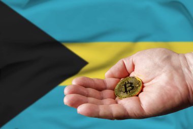 Altın Bitcoin bir adamın elinde, Bahama bayrağı arka planda..