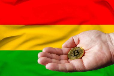 Altın Bitcoin bir adamın elinde, Bolivya bayrağı da arka planda.
