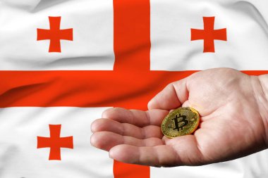Altın Bitcoin adamın elinde, Gürcistan bayrağı arka planda.