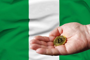 Altın Bitcoin bir adamın elinde, Nijerya bayrağı da arka planda.