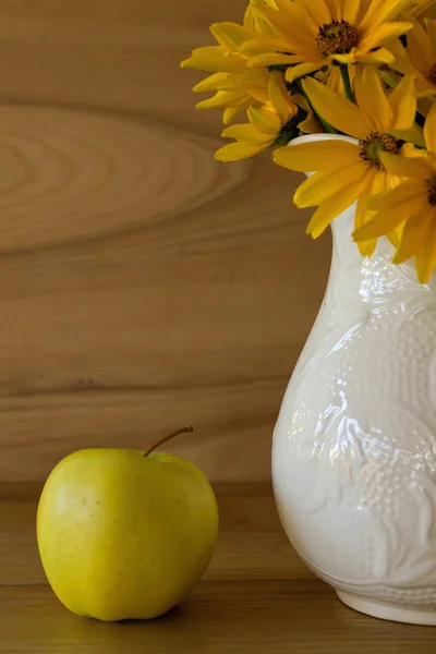 Flowers in a ceramic vase and apple — Stock Photo, Image