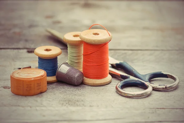 Tailor's tools - the old scissors, spools of thread, tape centim — Stock Photo, Image