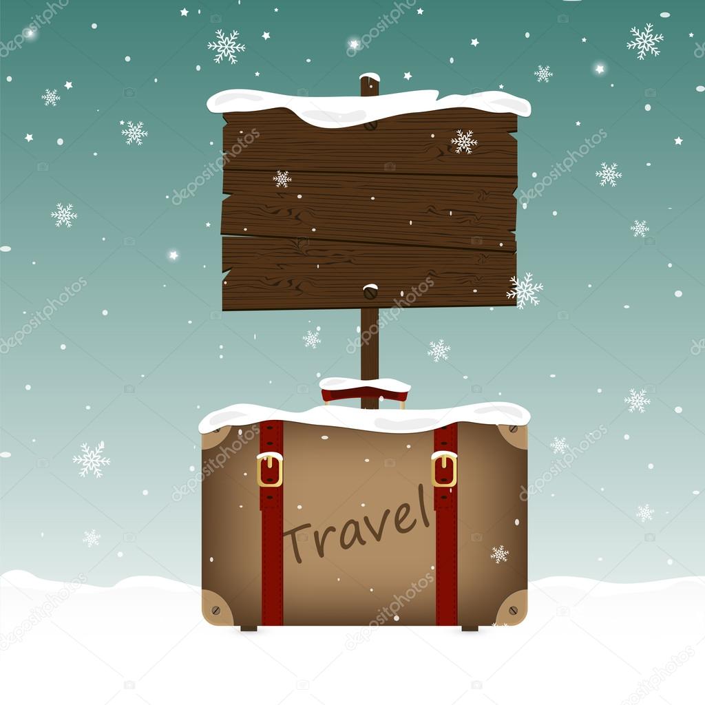 Travel suitcase and a wooden signboard in snow