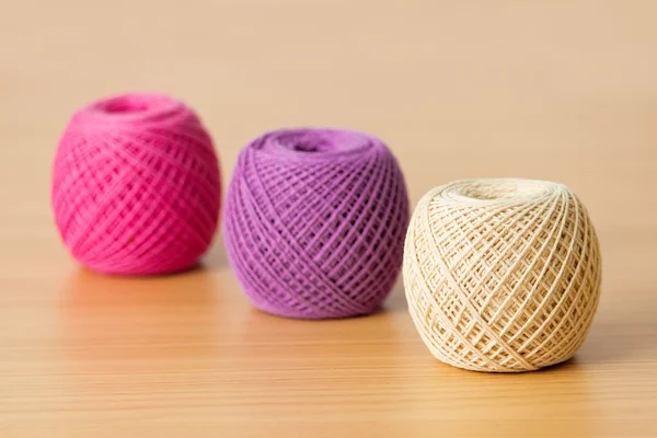 Balls of threads on a wooden table — Stock Photo, Image