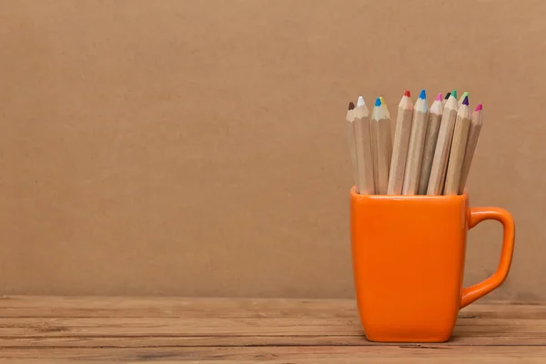Farbują ołówek w Pucharze na drewniane tła — Zdjęcie stockowe