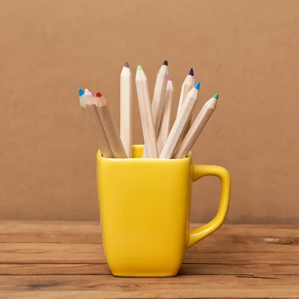 Lápis de cor na xícara em fundo de madeira — Fotografia de Stock