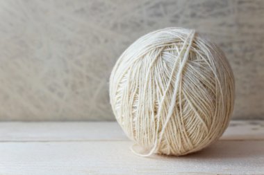 duvar kağıdı üzerinde ahşap bir masa üzerinde beyaz yumağı