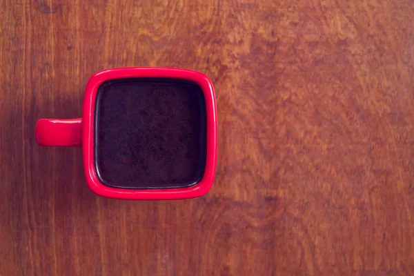 A red cup of coffee on wooden table. — Stock Photo, Image