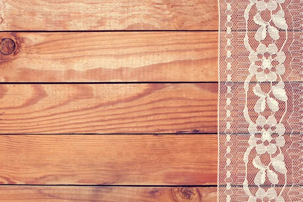 Hermoso encaje blanco con adorno floral en tablas de madera — Foto de Stock