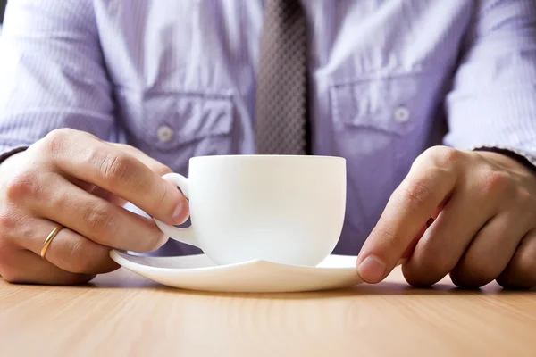 Close-up van handen van een jonge man met een kopje thee — Stockfoto