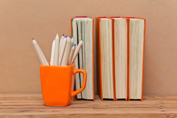 Stack of books and mug with colored pencils — Stock Photo, Image