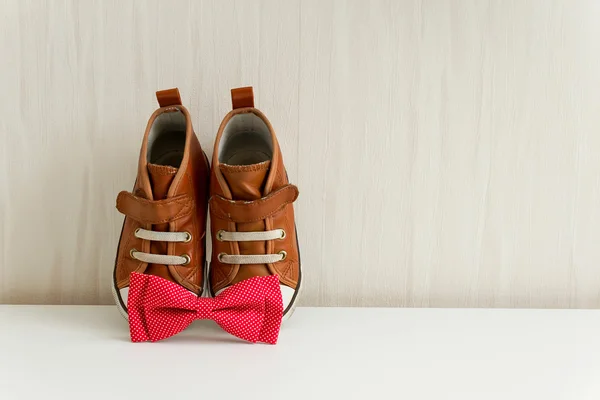 Bow tie and shoes on background wall with wallpaper — Stock Photo, Image