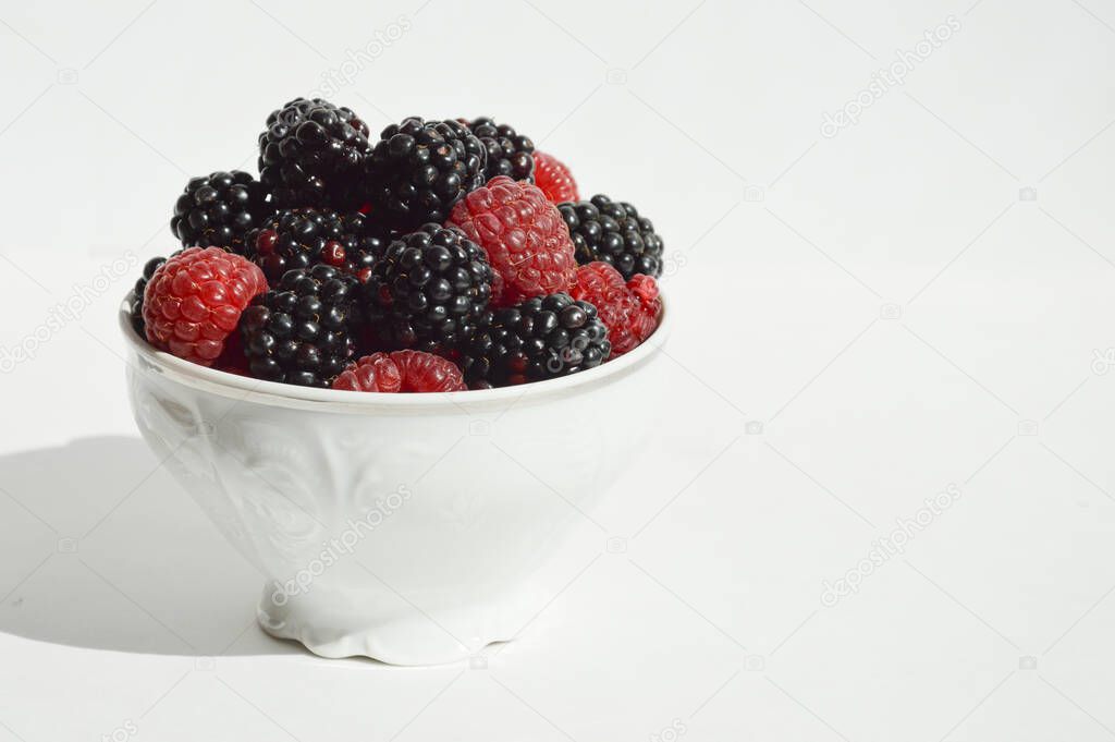 ripe, fresh berries. Raspberries and blackberries on a white background. vitamin dessert.
