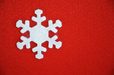 Kırmızı zemin üzerinde beyaz keçeli kar taneleri. Noel ve Yeni Yıl için dekorasyon. Kış tatili.