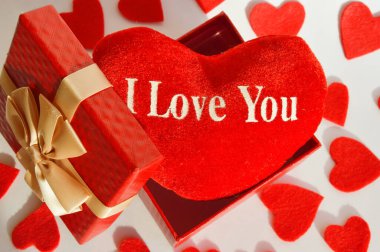 Sevgililer Günün kutlu olsun. Romantizm için arka plan. Güzel bir hediye kutusunda kırmızı bir kalp, şirin bir kartpostal, seni seviyorum..