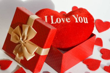 Sevgililer Günün kutlu olsun. Romantizm için arka plan. Güzel bir hediye kutusunda kırmızı bir kalp, şirin bir kartpostal, seni seviyorum..