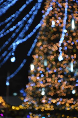 Renkli bokeh ışıkları. Mutlu Noeller ve yeni yılı kutlamak için parlak bir arka plan. Kış tatili için şehrin dekorasyonu..