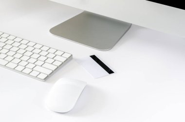 Kredi kartı, çevrimiçi ve Siber Pazartesi konsepti için kablosuz fare, klavye ve bilgisayar ekranının olduğu masaya koyar.