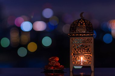 Fenerler ve küçük hurma tabakları. Gece gökyüzü ve şehir arkaplanı kutsal Ramazan Kareem bayramı için ışık saçar..