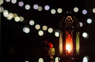 Kutsal Ramazan Kareem 'in Müslüman ziyafeti için arka planda bokeh ışığı olan fener ve hurma ağaçları.