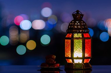 Fenerler ve küçük hurma tabakları. Gece gökyüzü ve şehir arkaplanı kutsal Ramazan Kareem bayramı için ışık saçar..