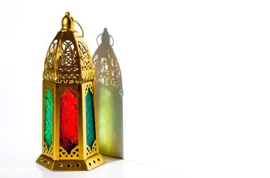 Beyaz arka planda güneş ışığının gölgesi olan altın fener. 