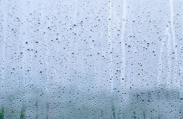 背景がぼやけているモンスーン期の日中のガラス窓に雨が降る — ストック写真