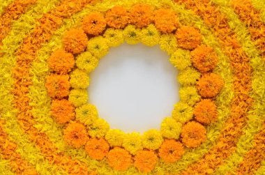 Decorative yellow and orange color marigold flowers and petals rangoli for Diwali festival with white space background.