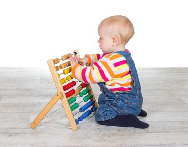 Menina bonito brincando com um ábaco — Fotografia de Stock