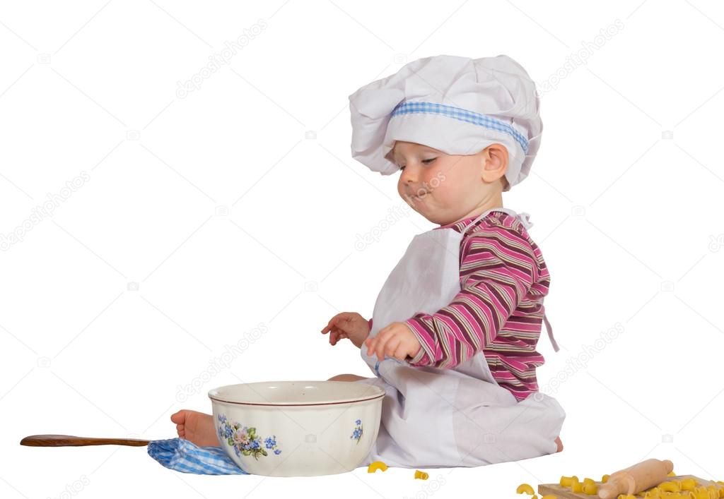 Satisfied little baby chef looking at mixing bowl