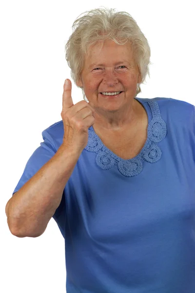 Seniorin mit erhobenem Zeigefinger — Stockfoto