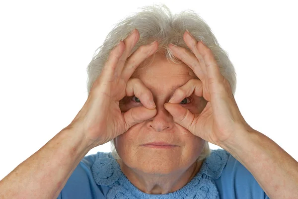 Mujer mayor mirando a través de binocular imaginario — Foto de Stock