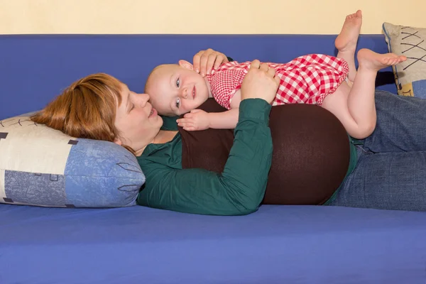 Menina bebê brincando com sua mãe grávida — Fotografia de Stock