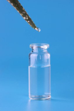 Aloe suyu temiz bir cam şişeye damlıyor.