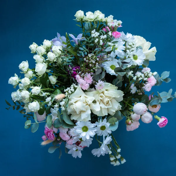 Bouquet of flowers on a blue background. Blooming flowers. Stock Image