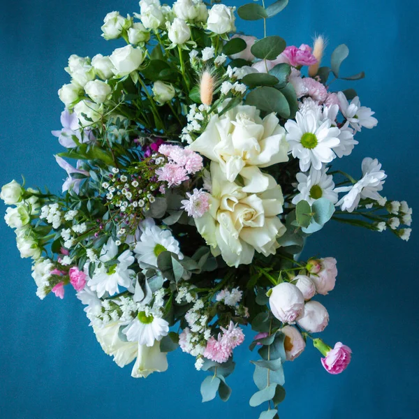 Mavi arka planda bir buket çiçek. Çiçek açan.