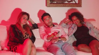 Kadın ve erkek kanepede oturuyor ve kanal değiştiriyor.