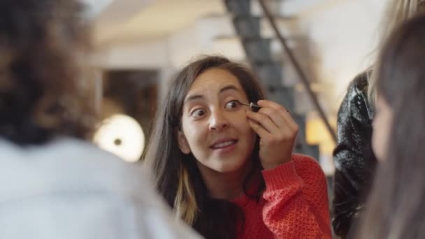 Mulher alegre olhando para o espelho e aplicando eyeliner — Vídeo de Stock