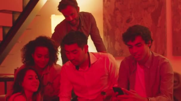 Vista frontal de amigos tomando selfie em apartamento com luz laranja — Vídeo de Stock