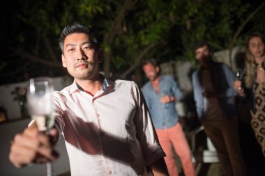 Partide şampanya kadehli genç adam.