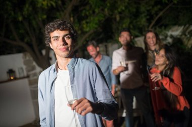 Partide şampanya kadehli genç kıvırcık adam.