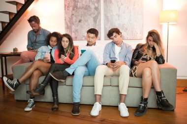 Ev partisinde sıkılmış genç erkekler ve kadınlar. Farklı milletlerden gelen bir grup erkek ve kadın otobüste oturuyor, birbirleriyle konuşmak yerine online iletişim kuruyorlar. Modern teknoloji kavramı